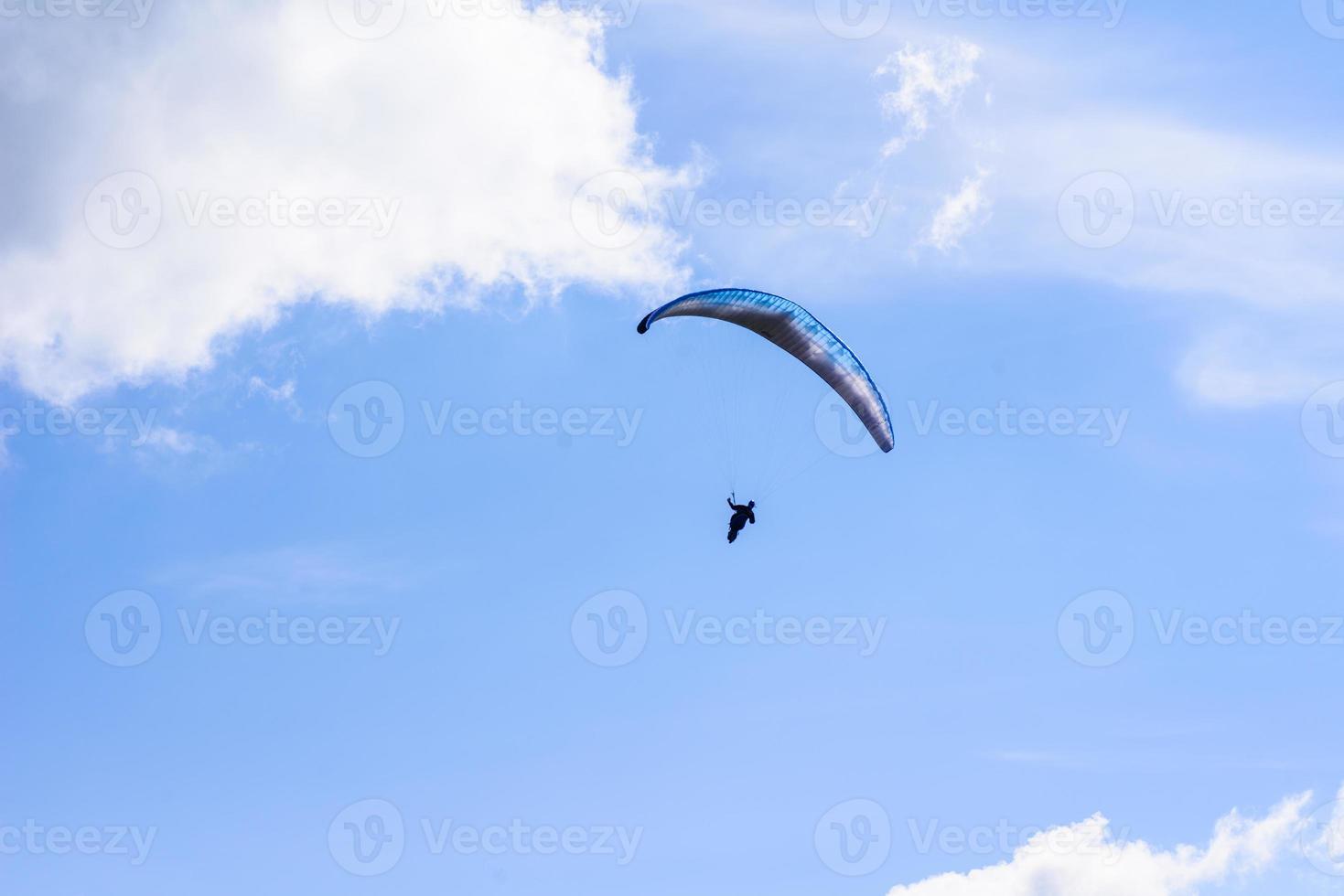 man on a parachute flying in the clear sky photo