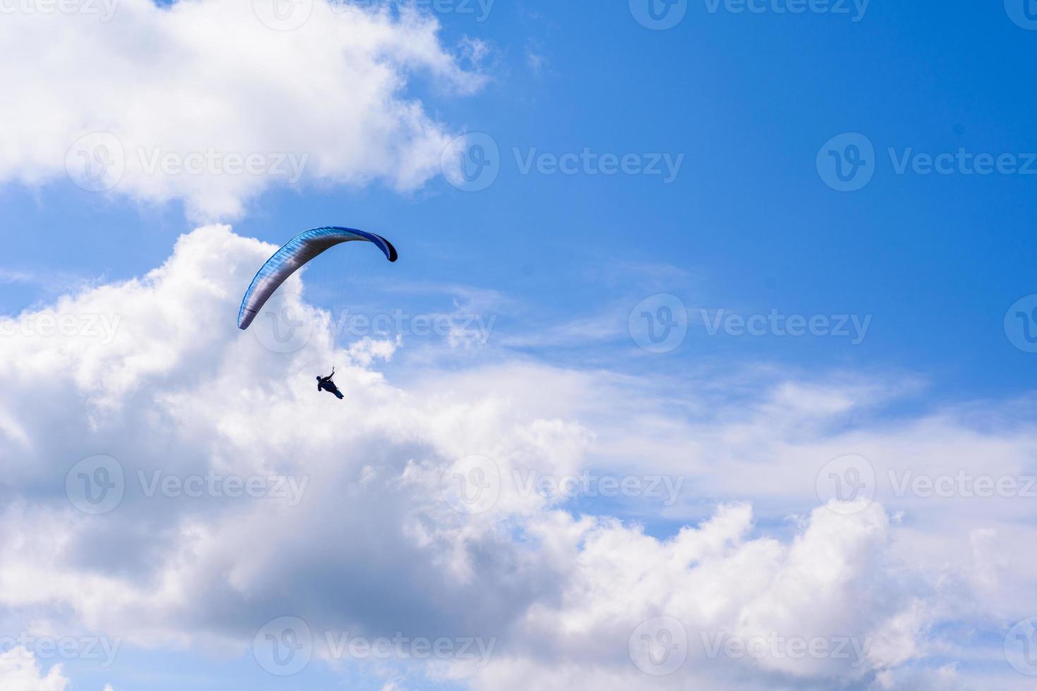 man on a parachute flying in the clear sky photo