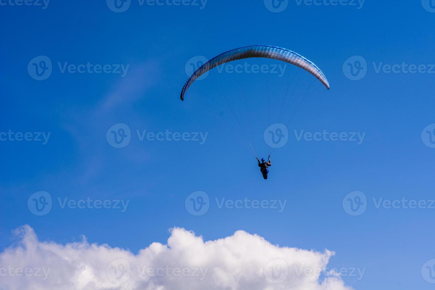 man on a parachute flying in the clear sky photo