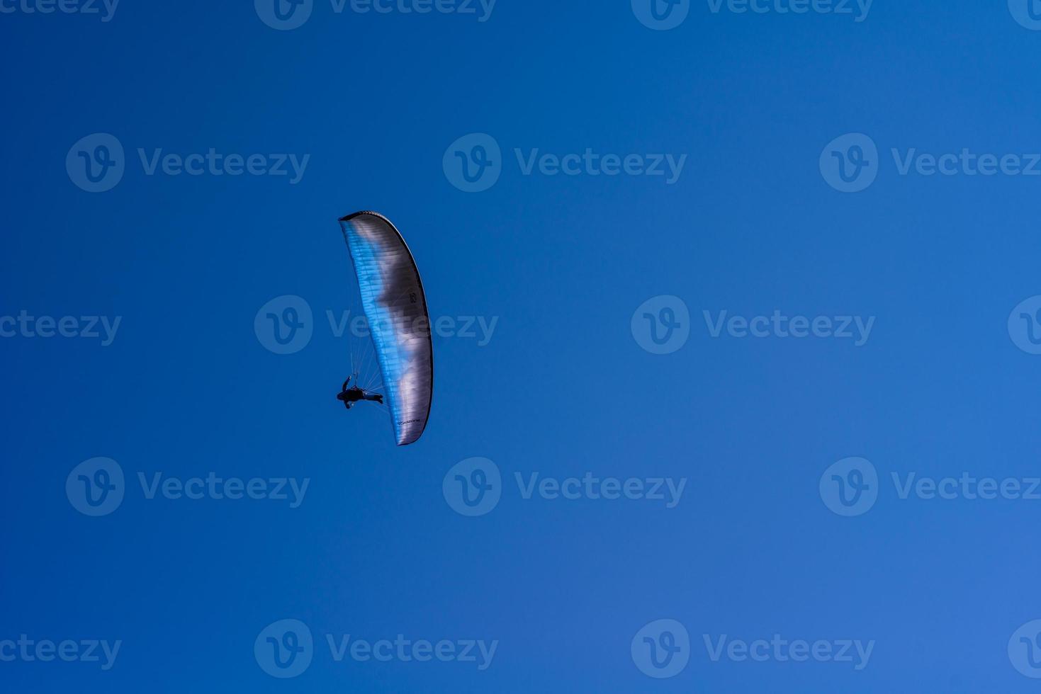 man on a parachute flying in the clear sky photo