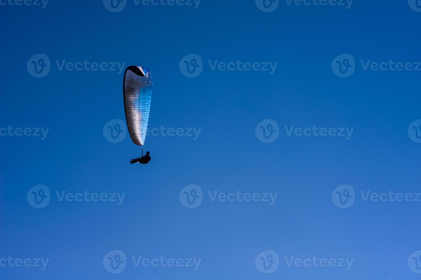man on a parachute flying in the clear sky photo