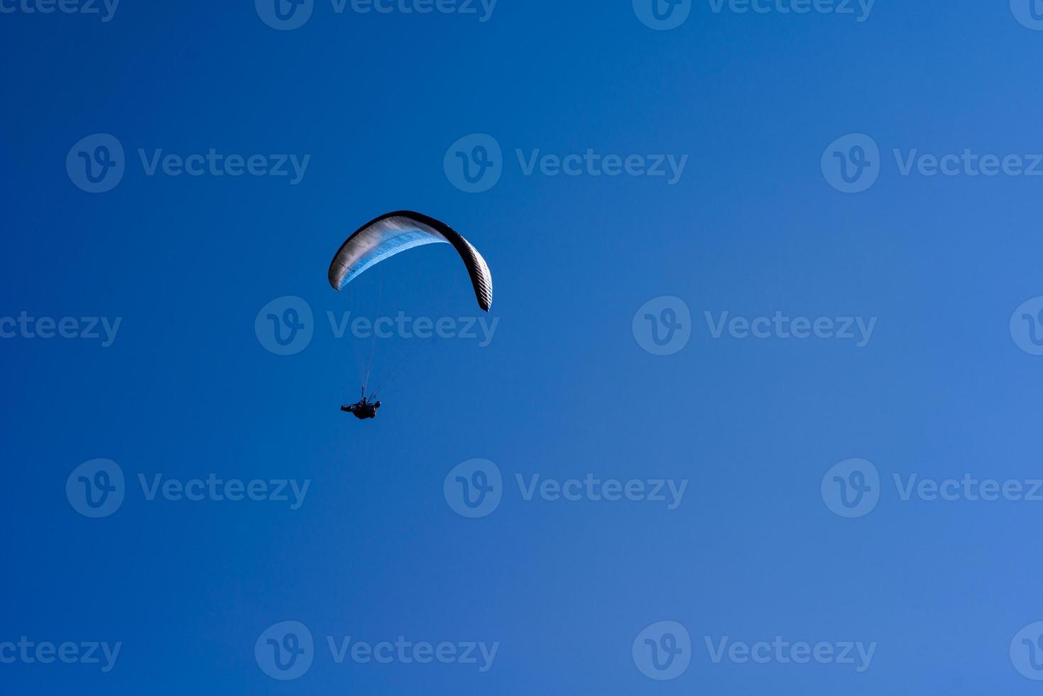 man on a parachute flying in the clear sky photo