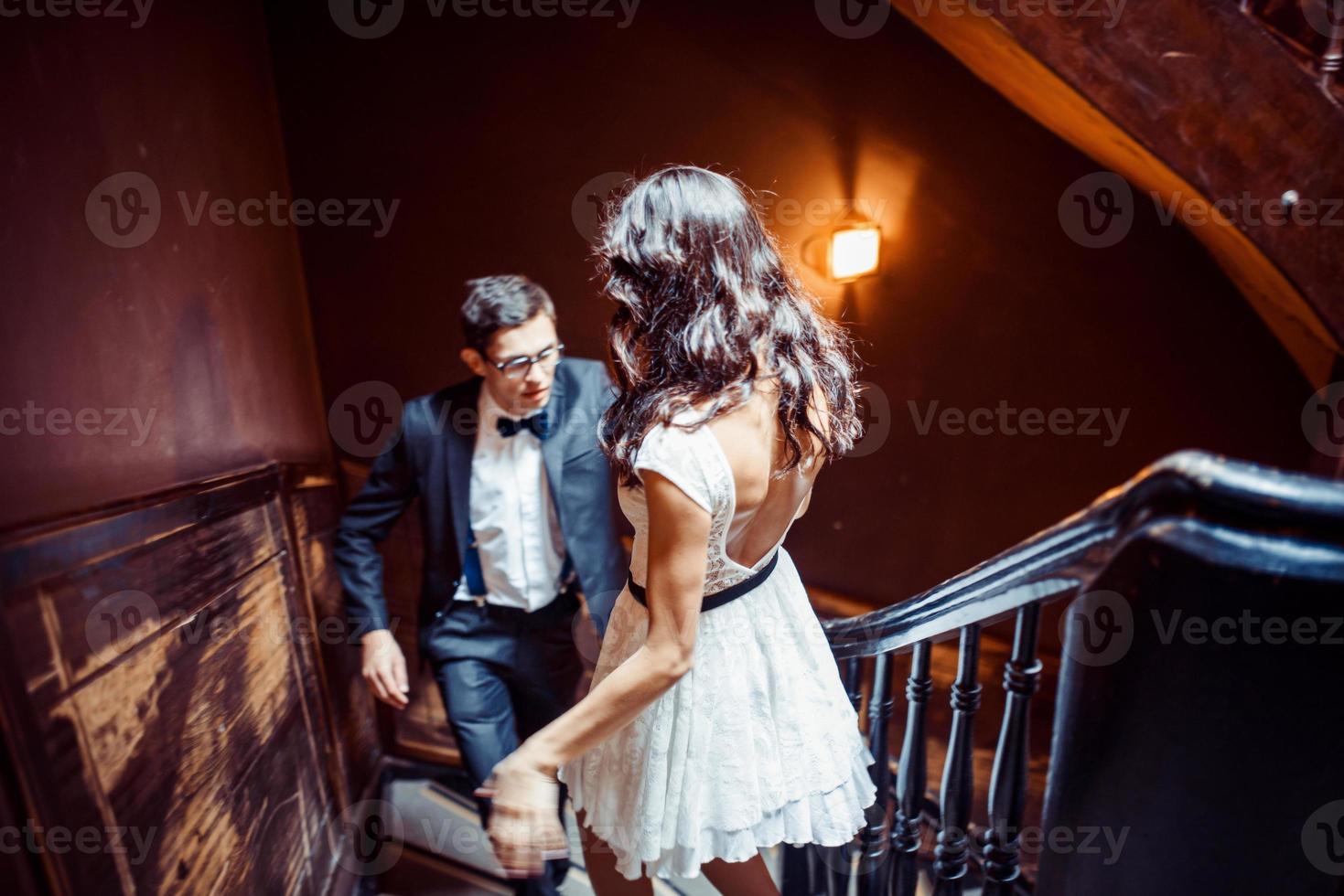 Fashionable young couple standing on stairs and hugging each other photo