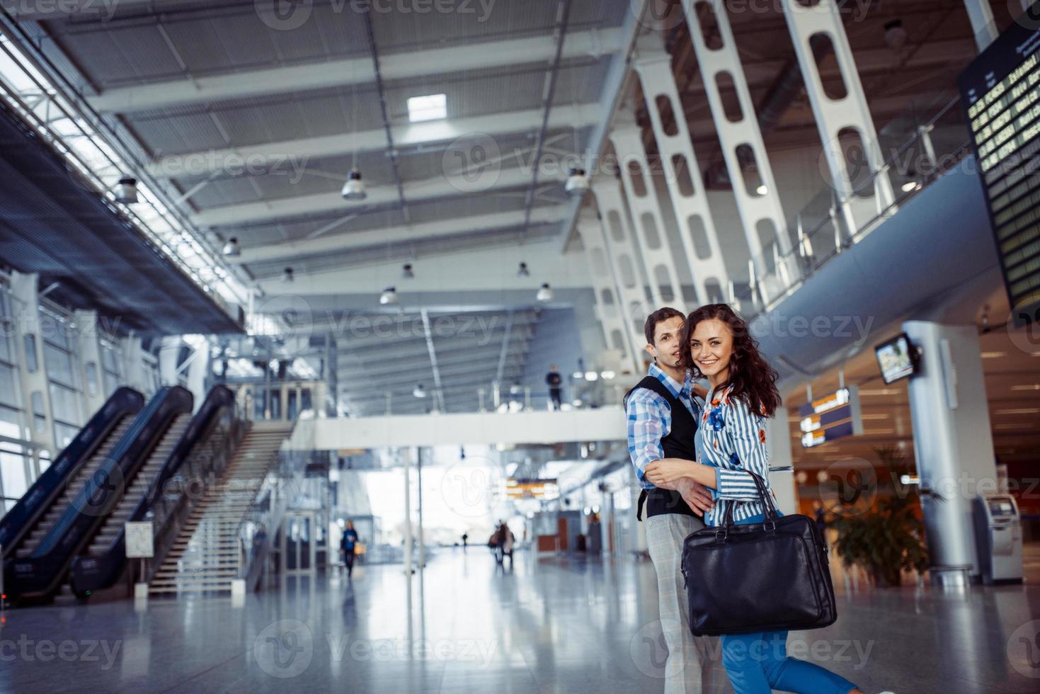 Young loving couple hugging in the airport terminal. photo