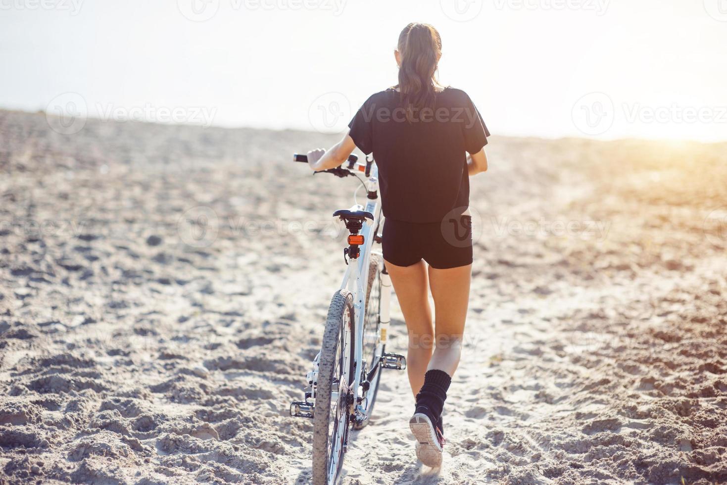 woman on a bicycle in beach photo
