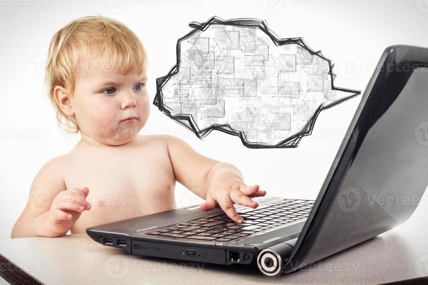 little girl is sitting at table with her black laptop photo