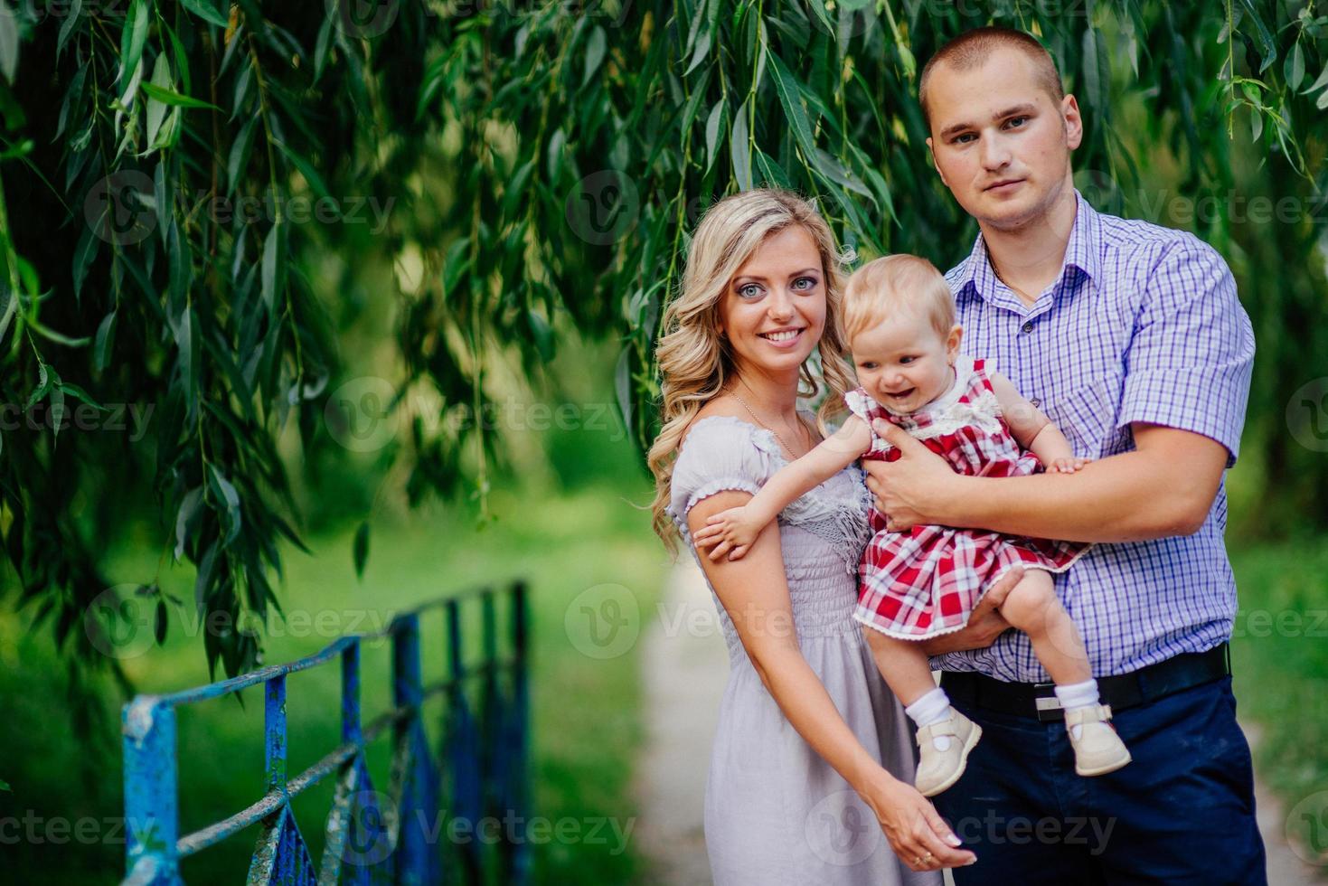 Happy mother, father and daughter in the park photo