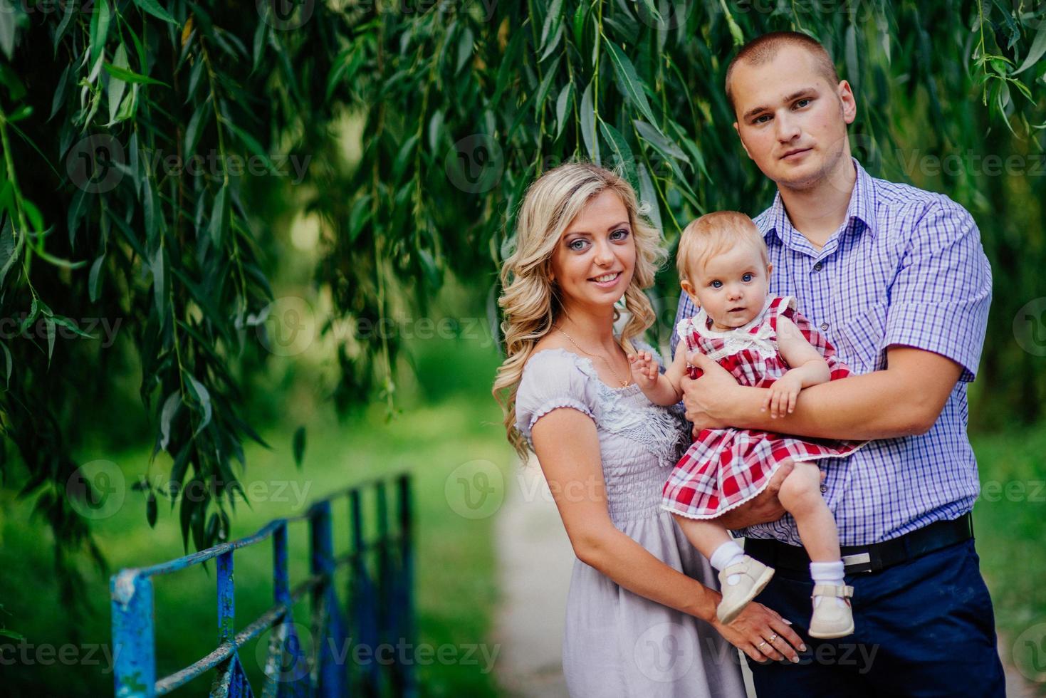 Happy mother, father and daughter in the park photo