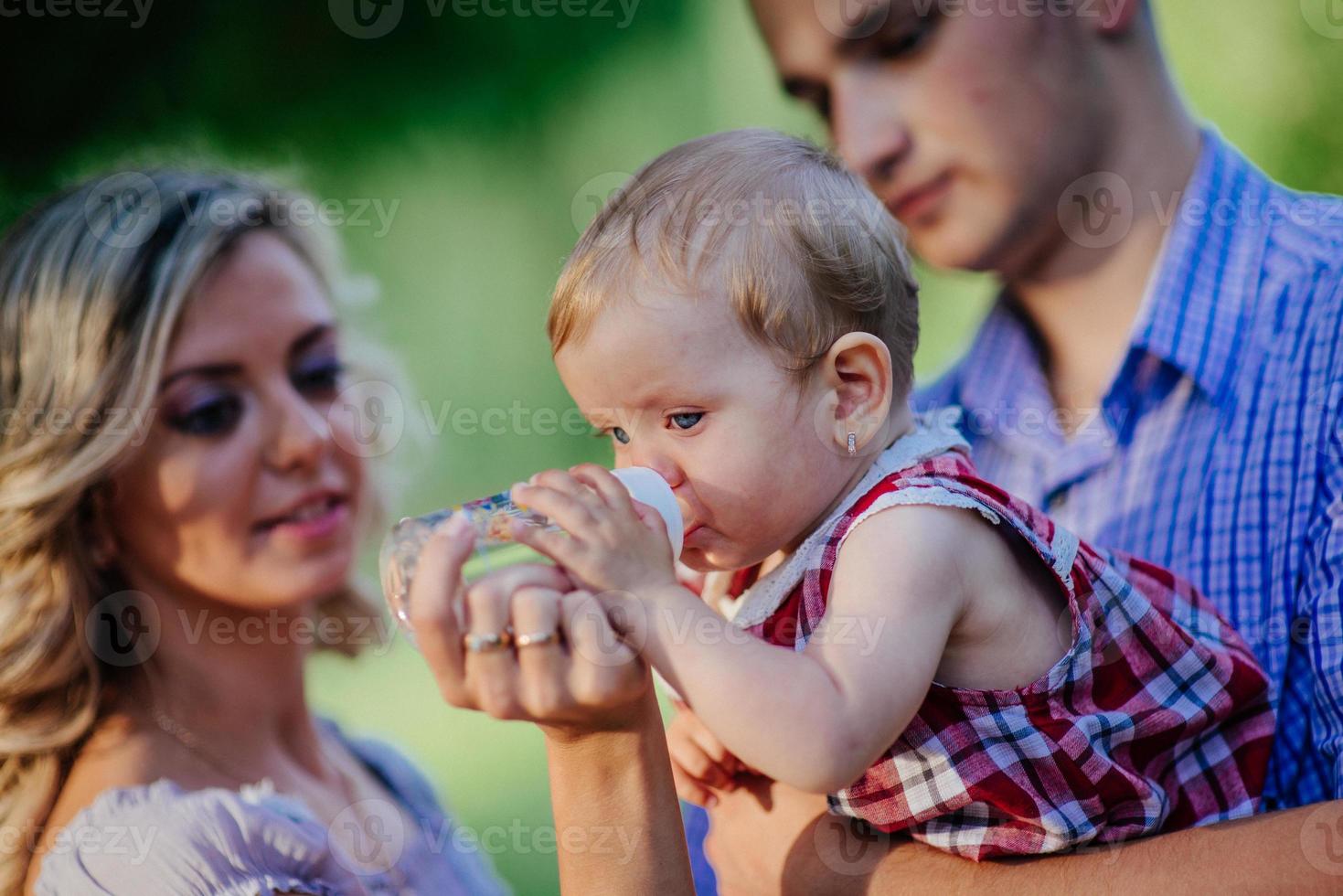 Happy mother, father and daughter in the park photo