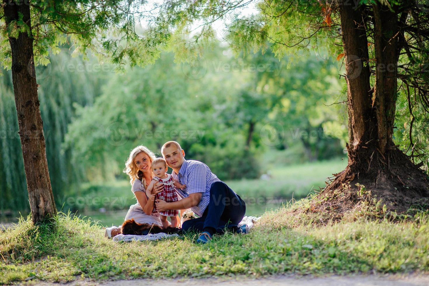 la familia feliz está caminando en el parque verde de verano foto