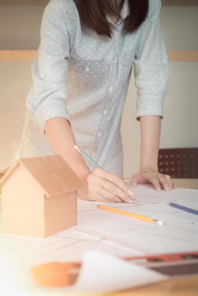 mujer arquitecta sola que trabaja con brújulas y planos para el plan arquitectónico, ingeniera que esboza un concepto de proyecto de construcción.concepto de arquitecto,efecto vintage foto