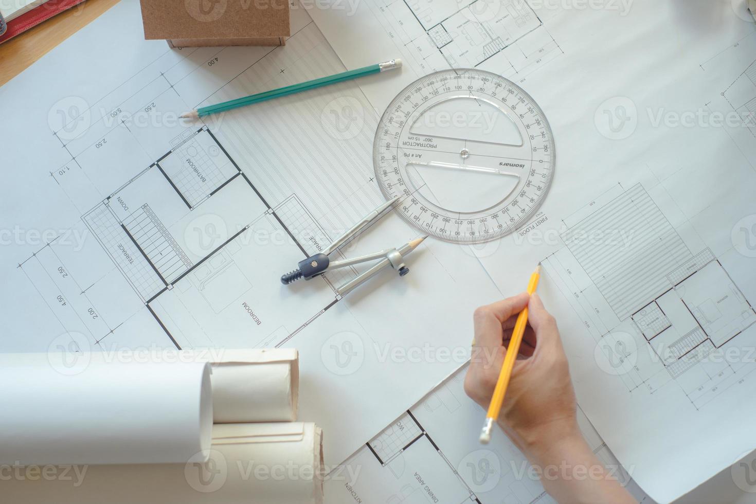 Hands of architect or engineer using drawing compass with blueprint on desk in office.Team of architects engineer discussing and check documents and business workflow.Construction concept. photo