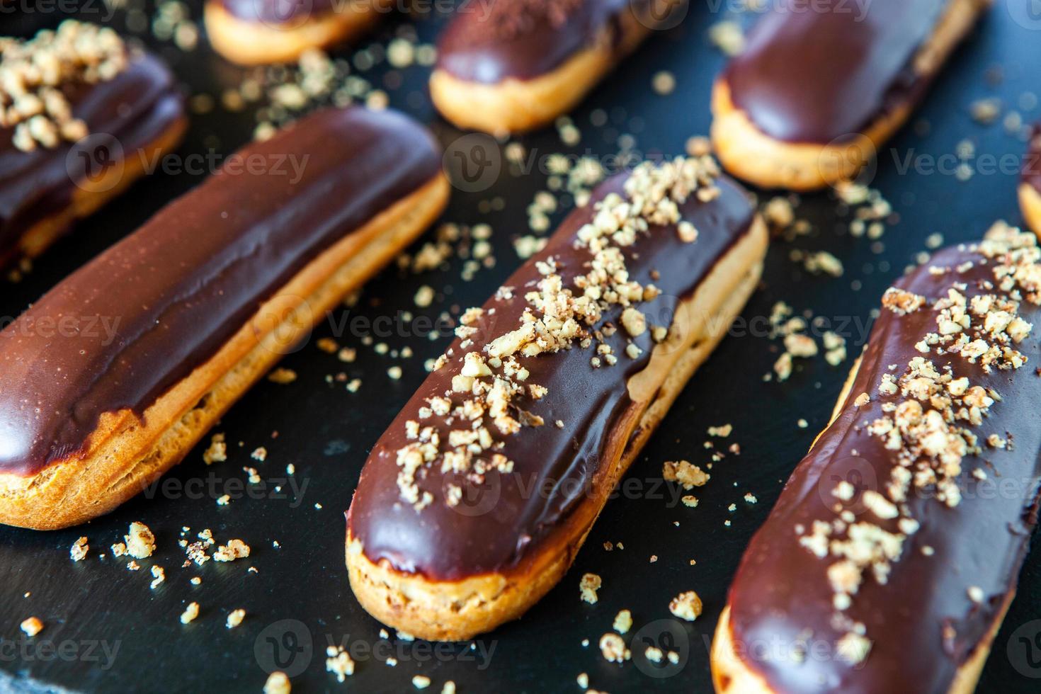 Traditional french eclairs with chocolate. Tasty dessert. Home made cake eclairs. Sweet Dessert Pastry filled with cream. Chocolate icing. photo