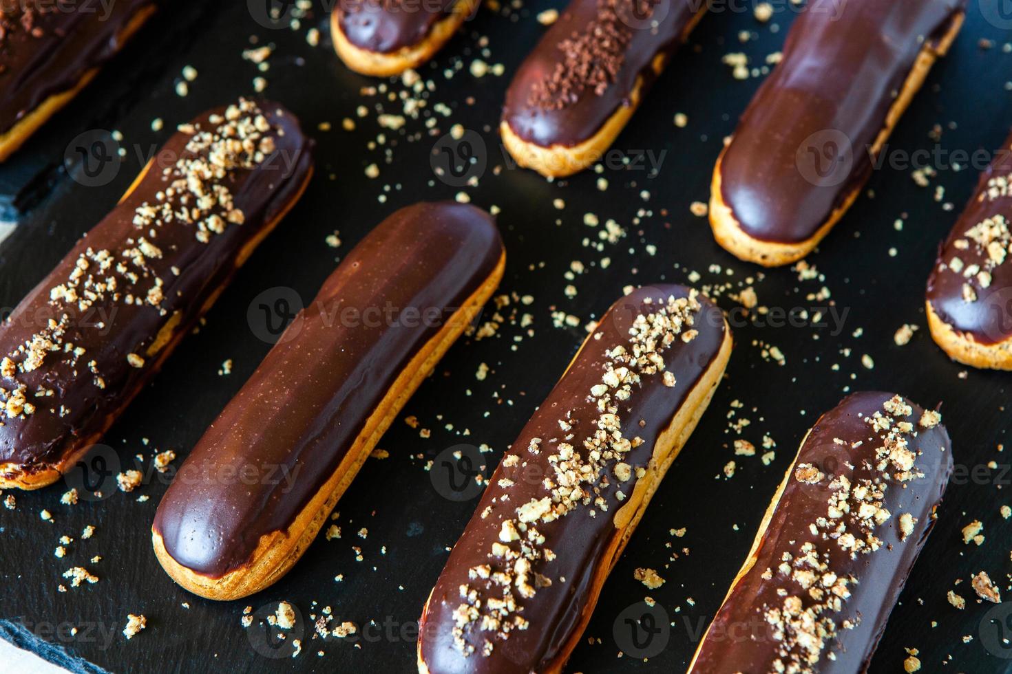 Traditional french eclairs with chocolate. Tasty dessert. Home made cake eclairs. Sweet Dessert Pastry filled with cream. Chocolate icing. photo