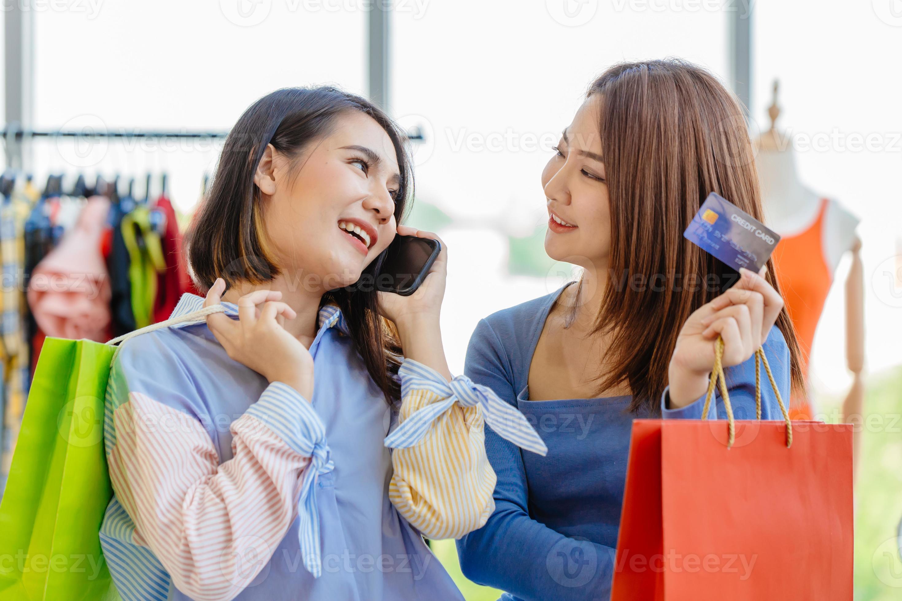 Asian girls enjoy shopping with cashless credit card phone calling loan