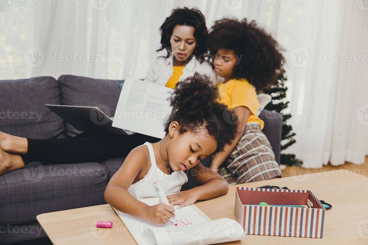 los padres trabajan en casa desde la computadora portátil de Internet efecto de la enfermedad pandémica del virus covid-19 madre sana vida feliz para quedarse y jugar con sus hijos foto