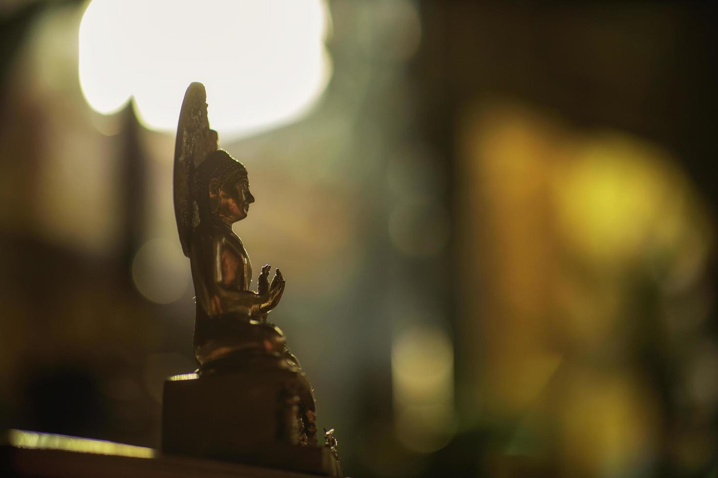 Seated Buddha image with sunlight in the background. photo