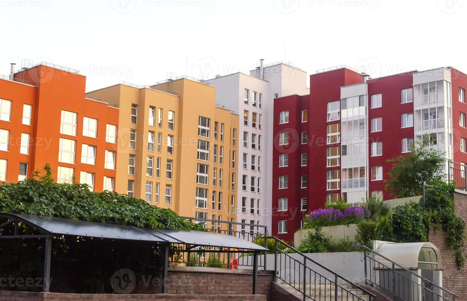Modern multi-colored apartment building with playground and garden. photo