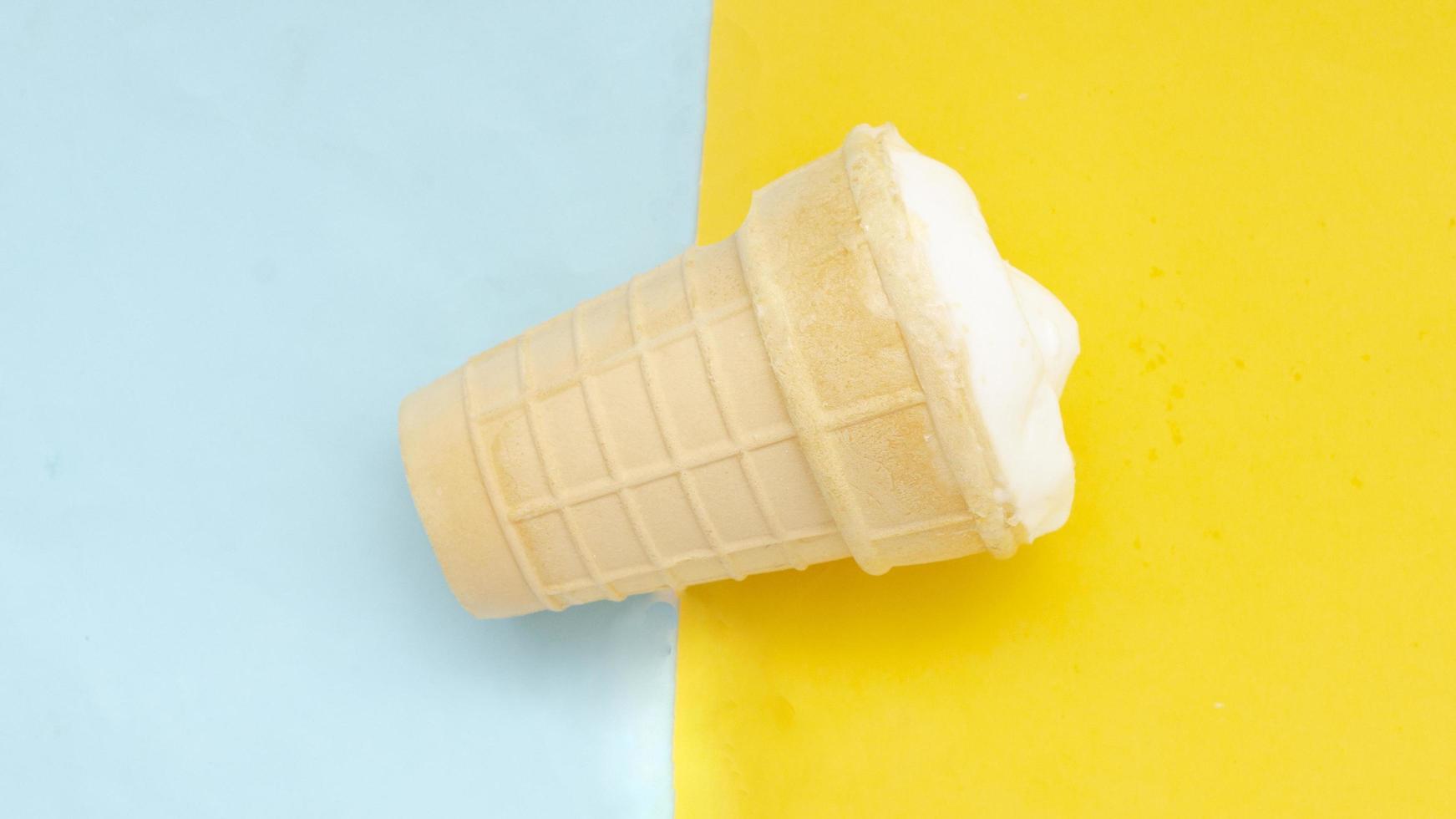 Waffle cup of cream ice cream on pastel blue yellow background. photo