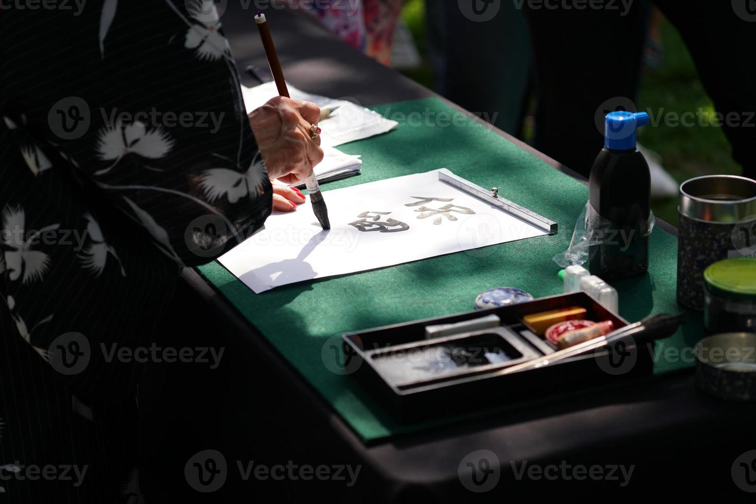 japanese calligraphy with ink brush on paper photo