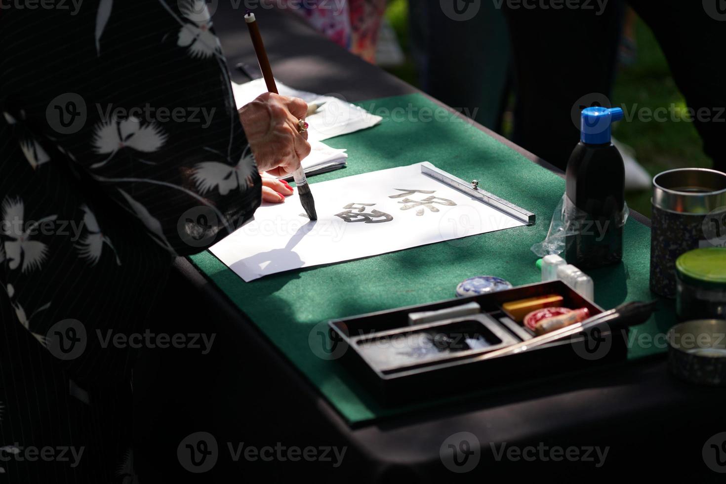 caligrafía japonesa con pincel de tinta sobre papel foto