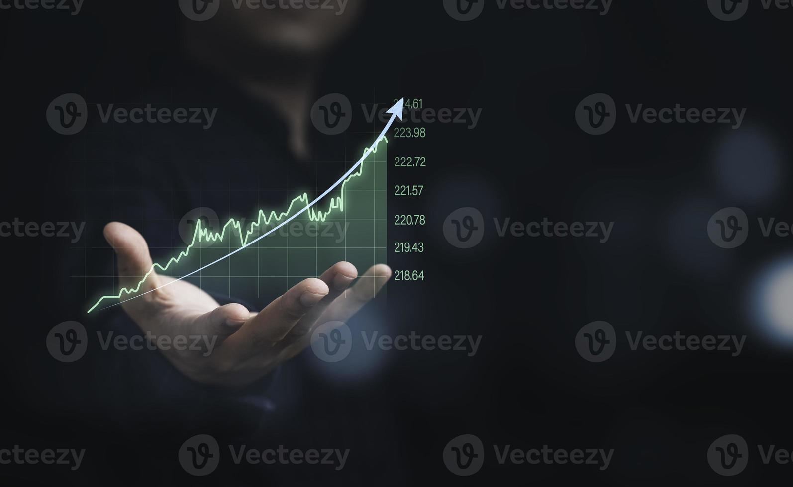 hombre de negocios que sostiene un gráfico técnico virtual y un gráfico para el análisis del mercado de valores, la inversión en tecnología y el concepto de inversión de valor. foto