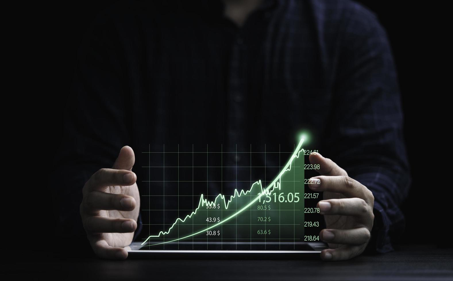 Two hands of trader protecting green graph chart with arrow for analysis stock market information , Investment concept. photo