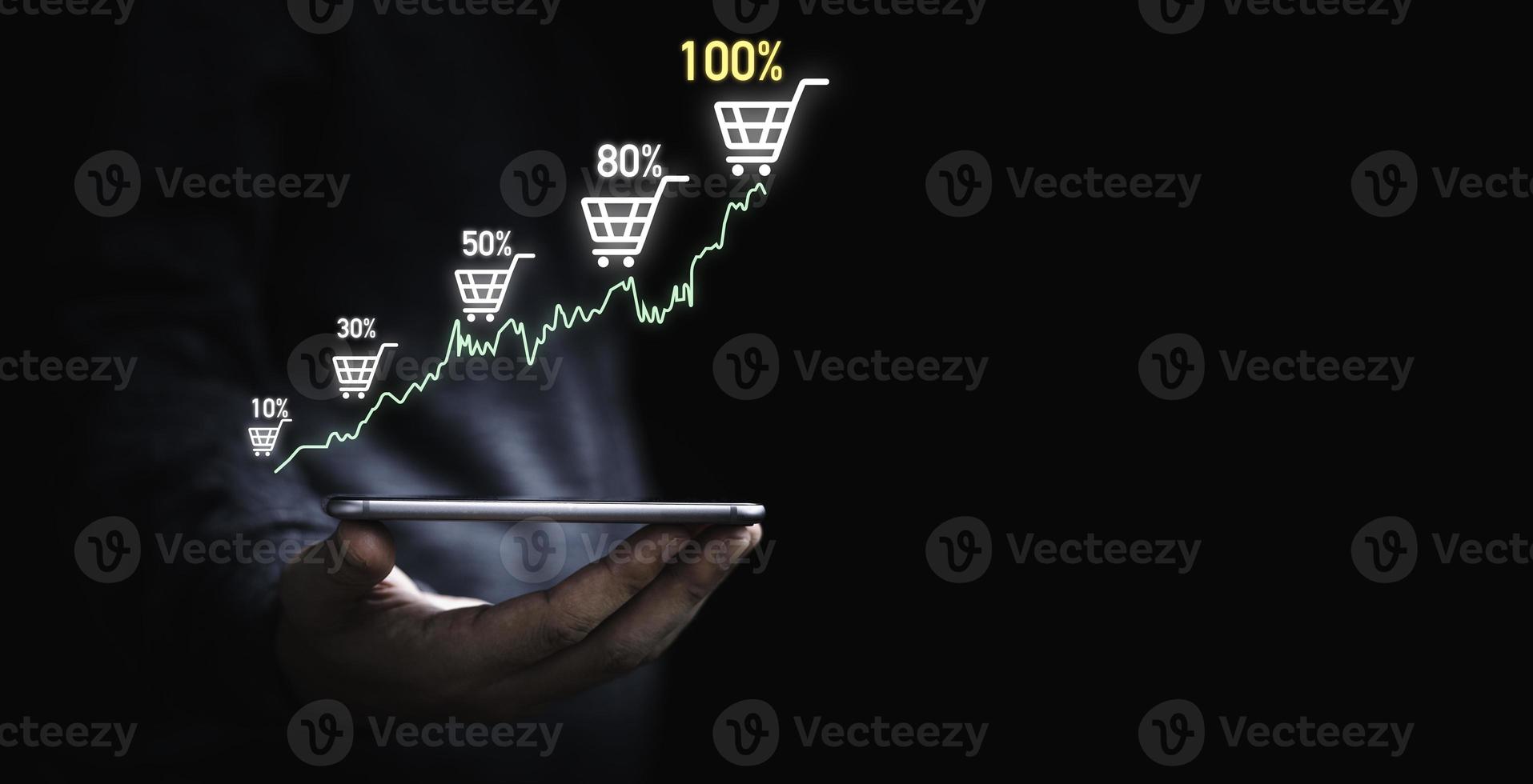 hombre de negocios que sostiene un teléfono inteligente que muestra un gráfico virtual y un carrito de compras para aumentar el concepto de crecimiento del negocio de venta en línea. foto