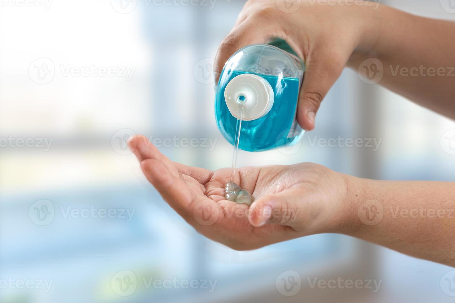 woman using alcohol rub. Coronavirus hand sanitizer sanitiser gel for clean hands hygiene corona virus spread prevention. photo