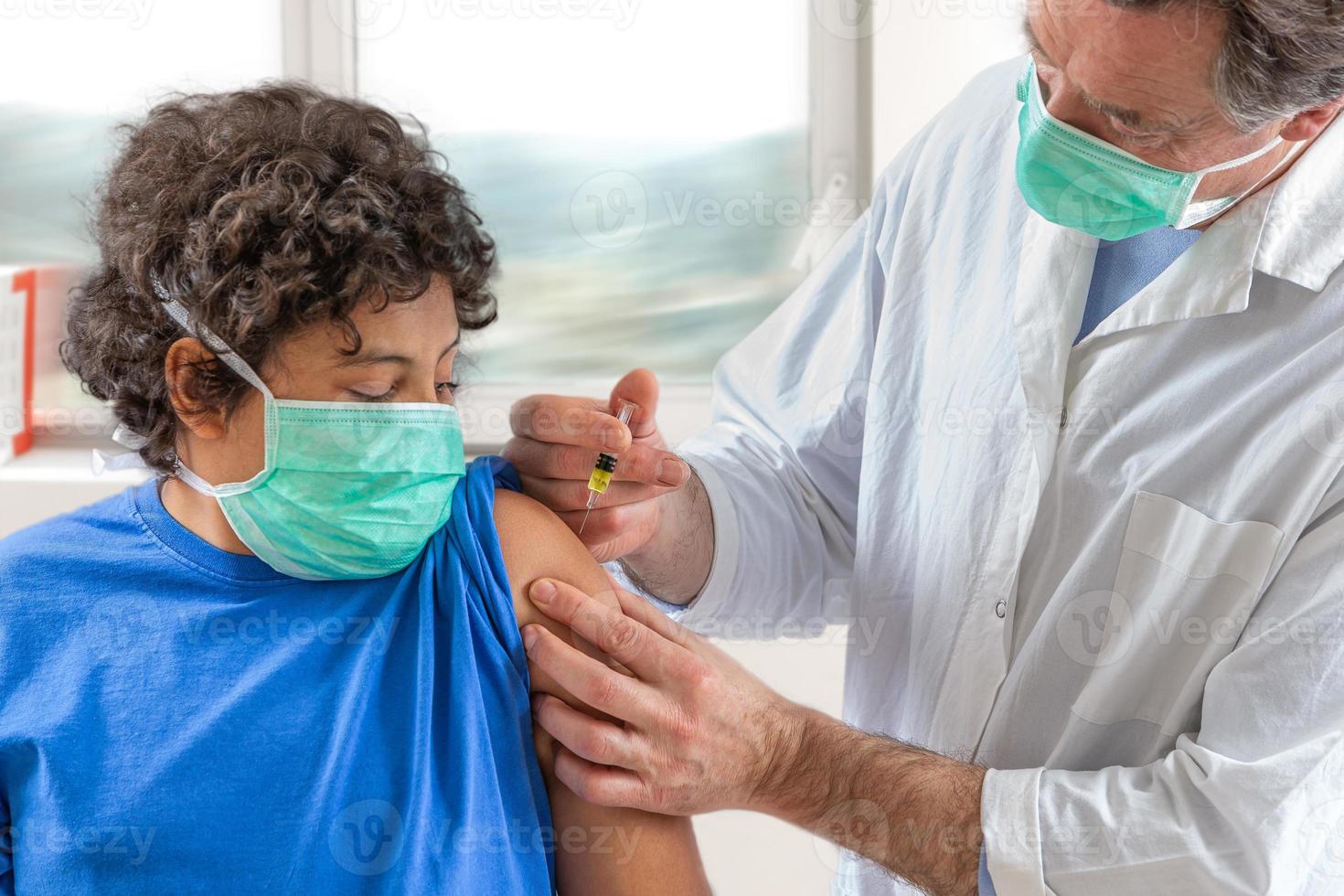 Male doctor in protective face mask latex gloves giving intramuscular vaccination protected patient's arm photo