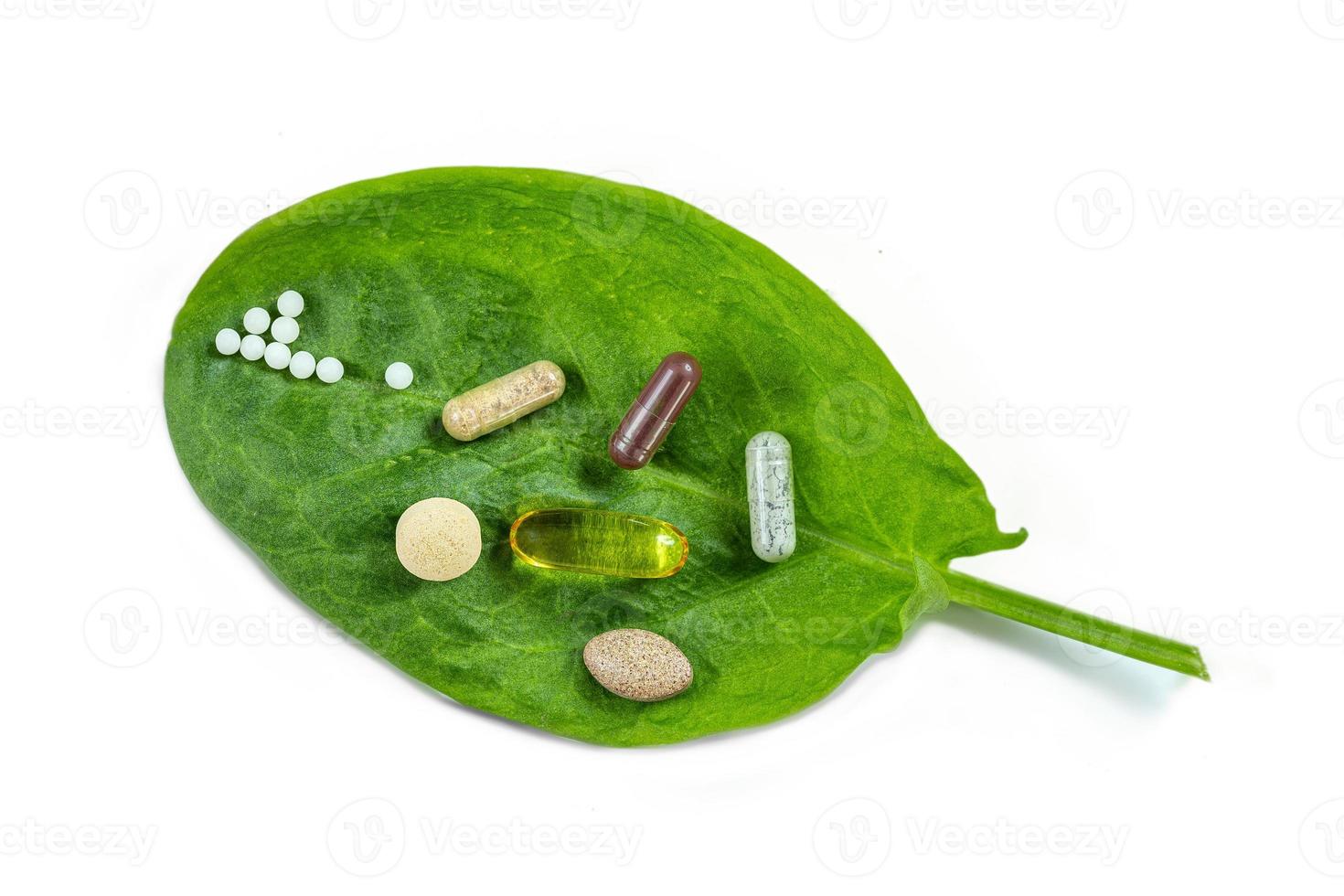 Homeopathy - A homeopathy concept with homeopathic medicine and food supplement on green leaves photo