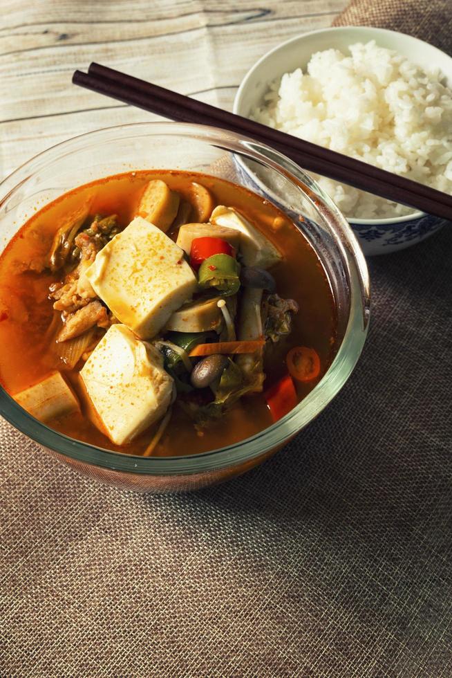 Korean soup, kimchi, tofu, pork with steamed rice photo