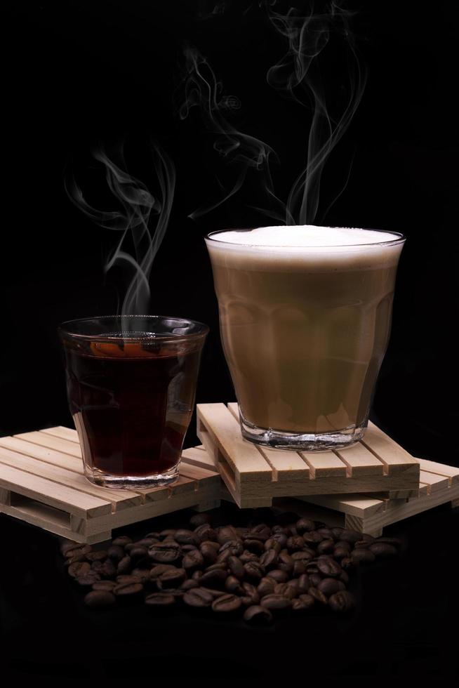 café con leche caliente con té caliente sobre fondo negro foto