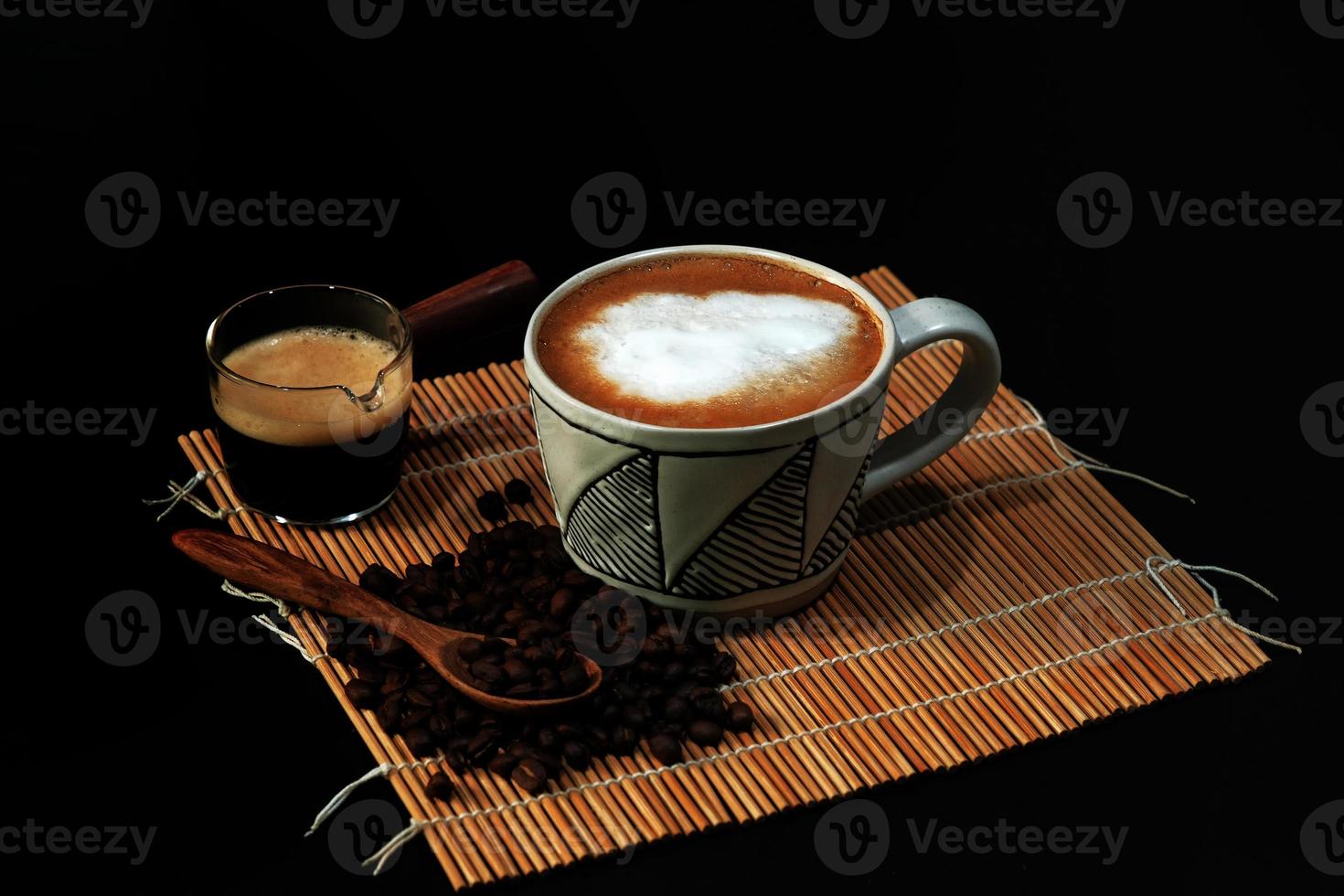 hot latte with coffee beans on dark background photo