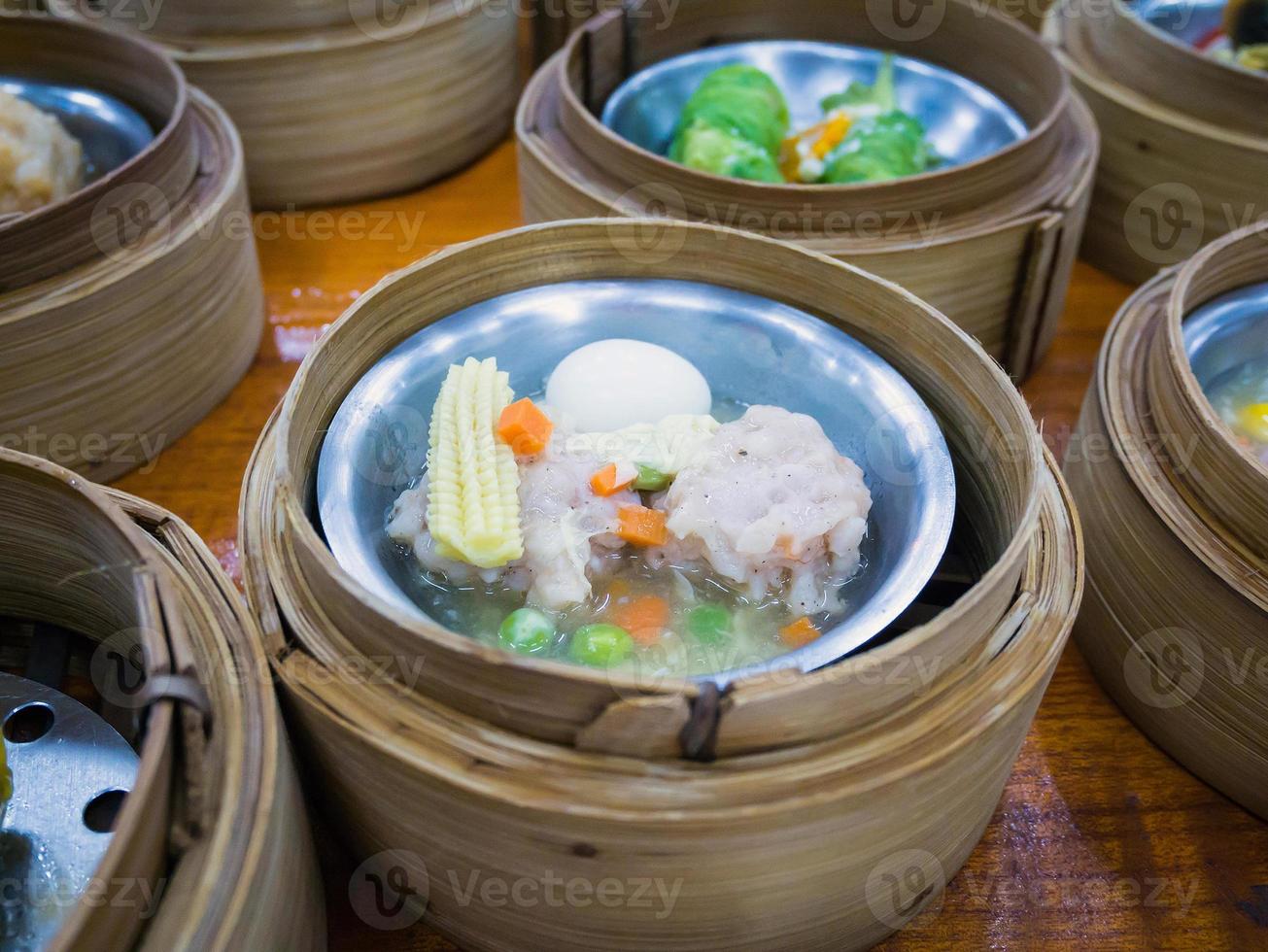 varios dim sum en vaporera de bambú foto