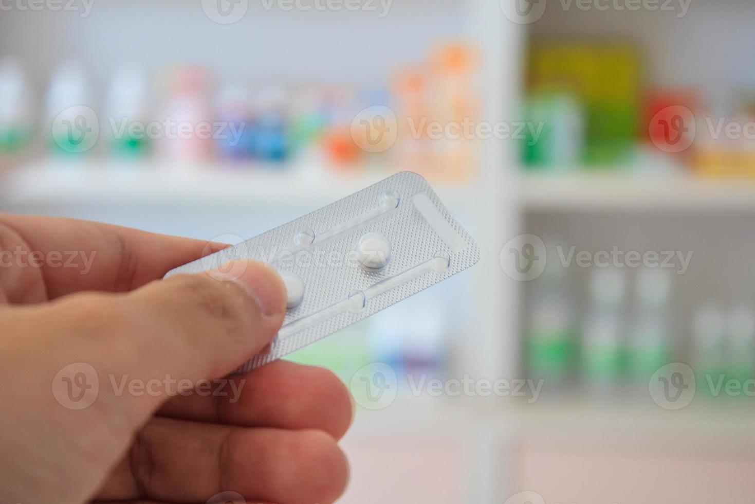 Close up of pharmacist hands holding contraceptive pills photo