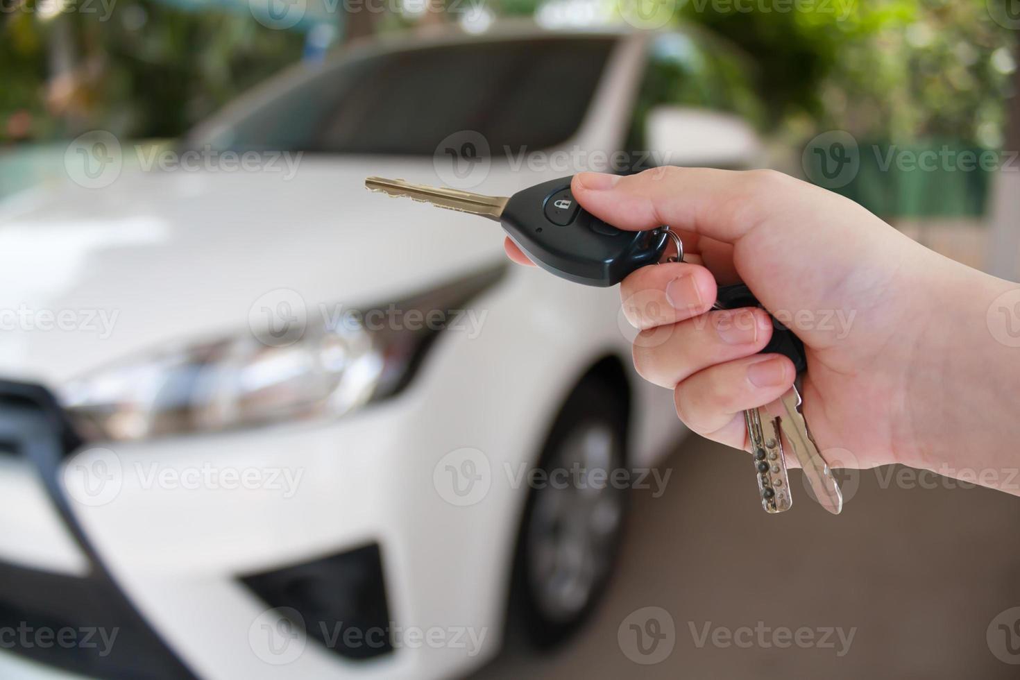 women hand presses on the remote control car alarm systems photo