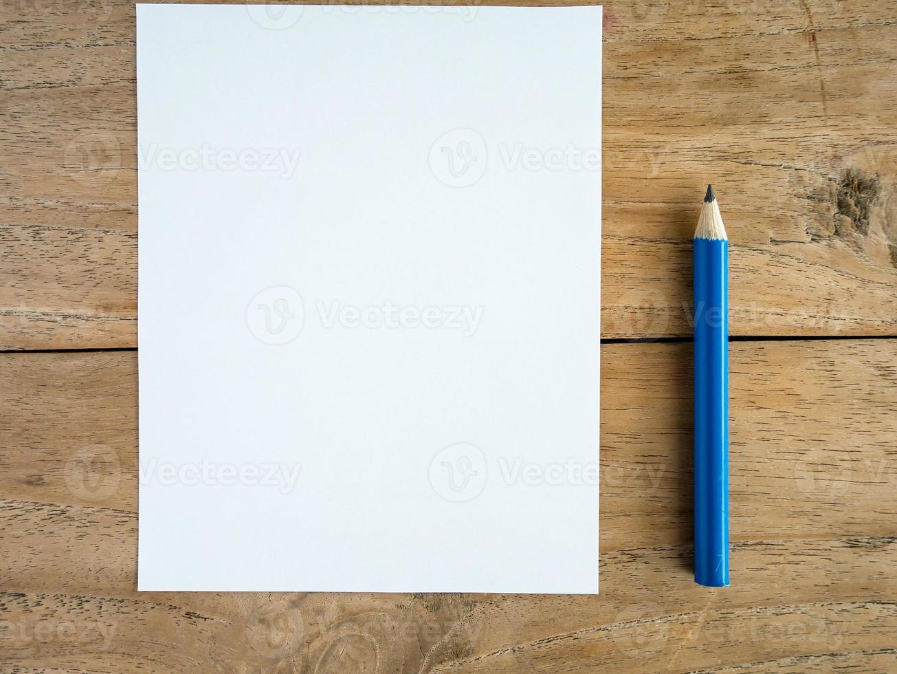 Blank paper with pencil on wood table photo