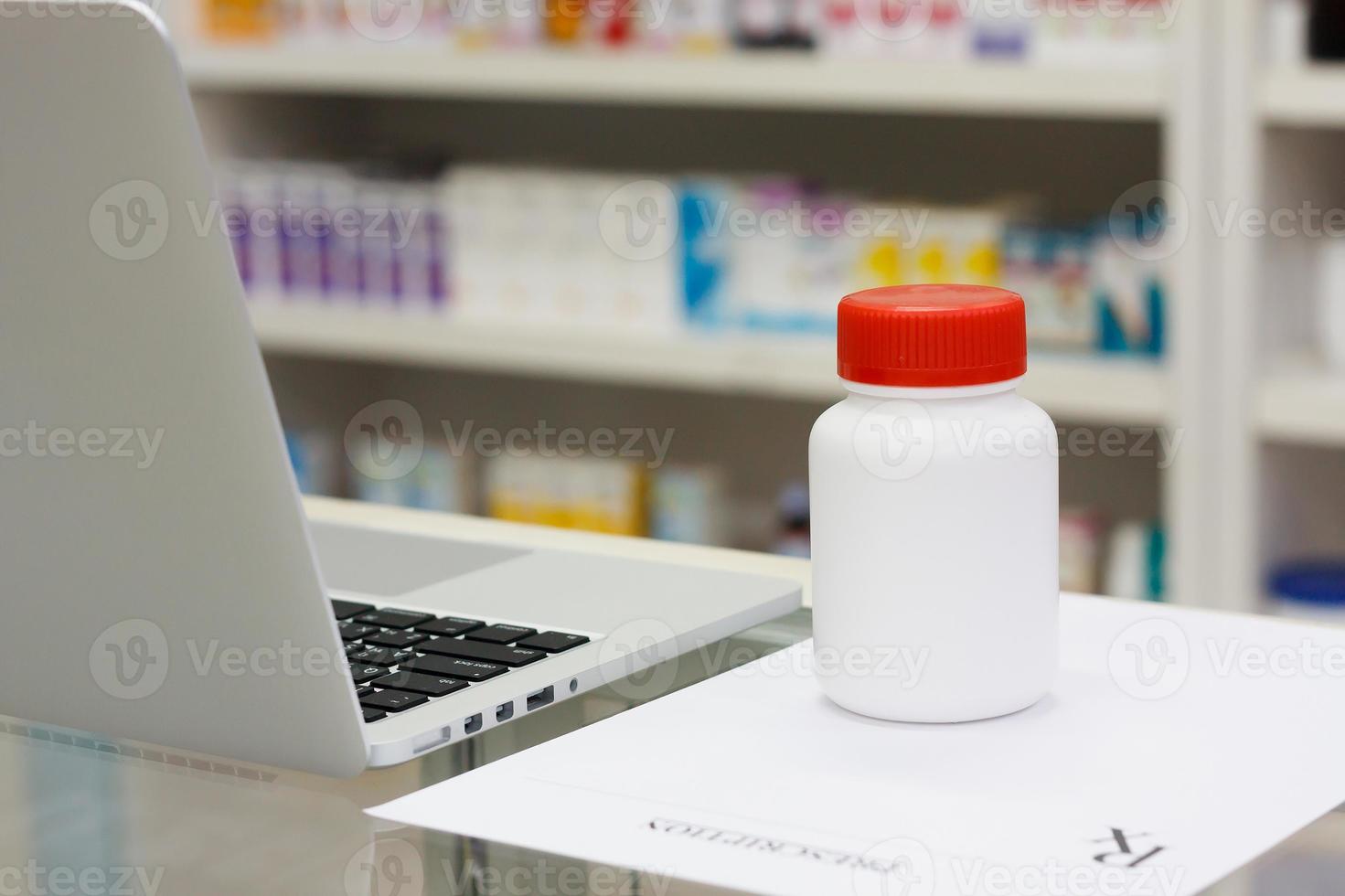 medicine bottle and laptop computer in the pharmacy photo