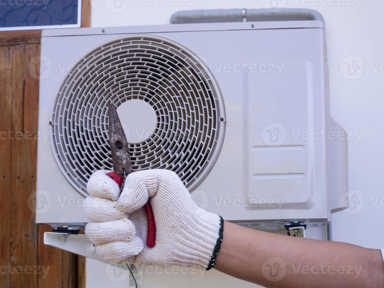 technician installing outdoor air conditioning unit photo