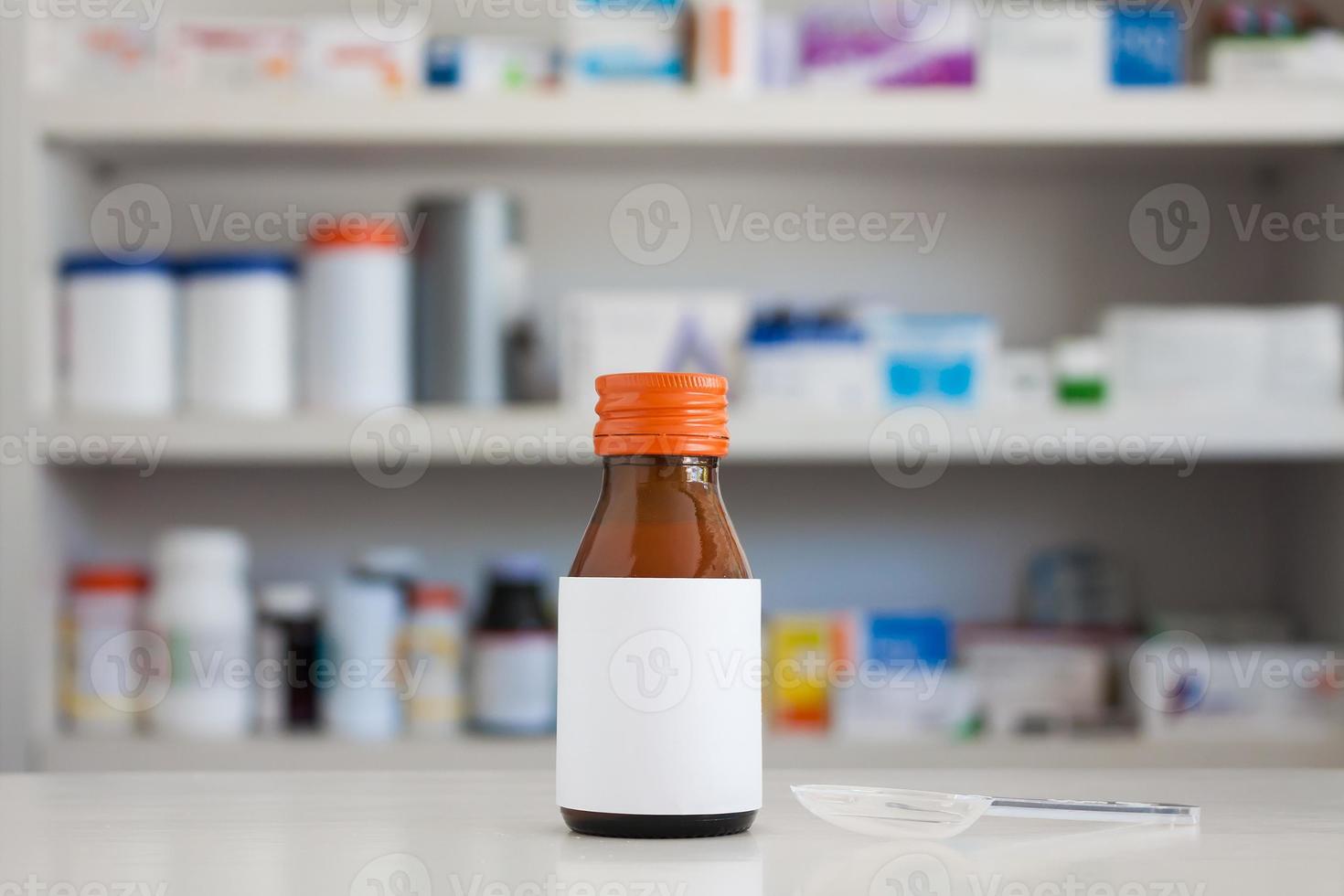 Blank white label of medicine bottle with blur shelves of drug in the pharmacy drugstore background photo