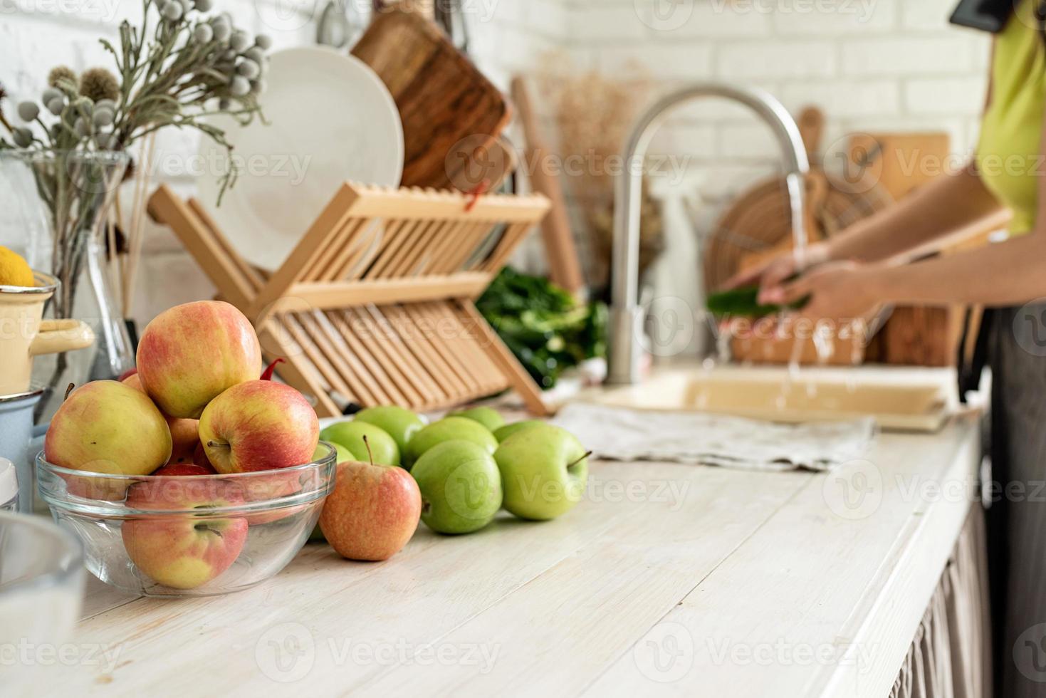 Close up of table with green vegetables and fresh fruit in the kitchen photo