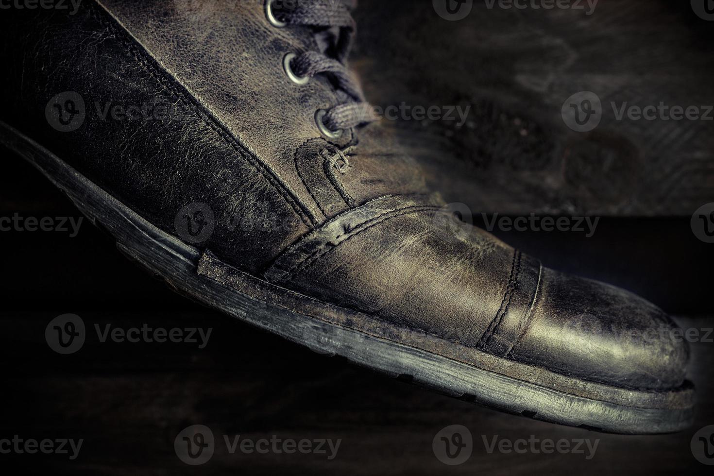 Detail of gray leather casual shoe for man on wooden board. Dark mood style. Horizontal image. photo