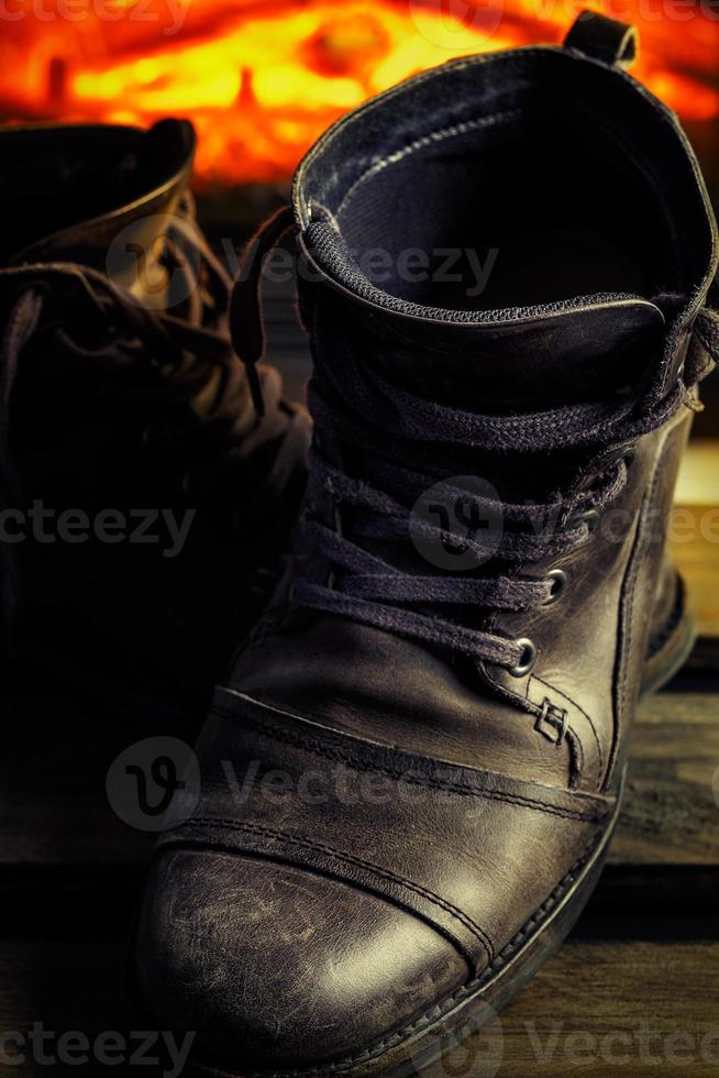 Casual gray leather shoes for men on wooden board with fireplace in the background. Dark mood style. Vertical image. photo