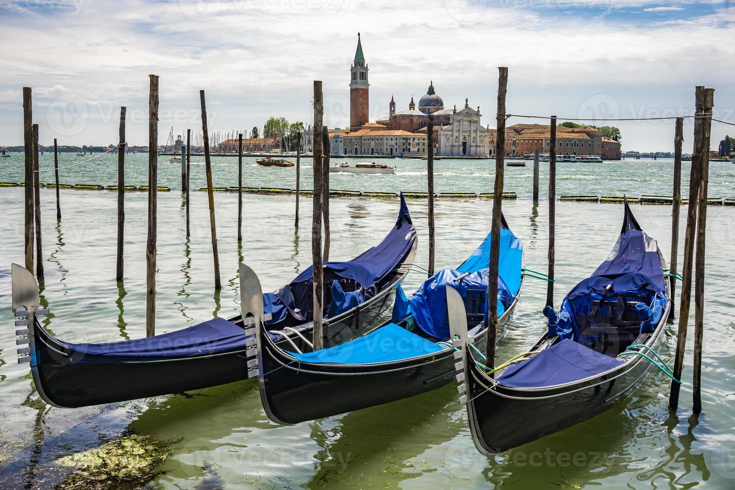 Traditional gondolas floating on the canal in Venice, in front of island San Giorgio Maggiore, Italy photo