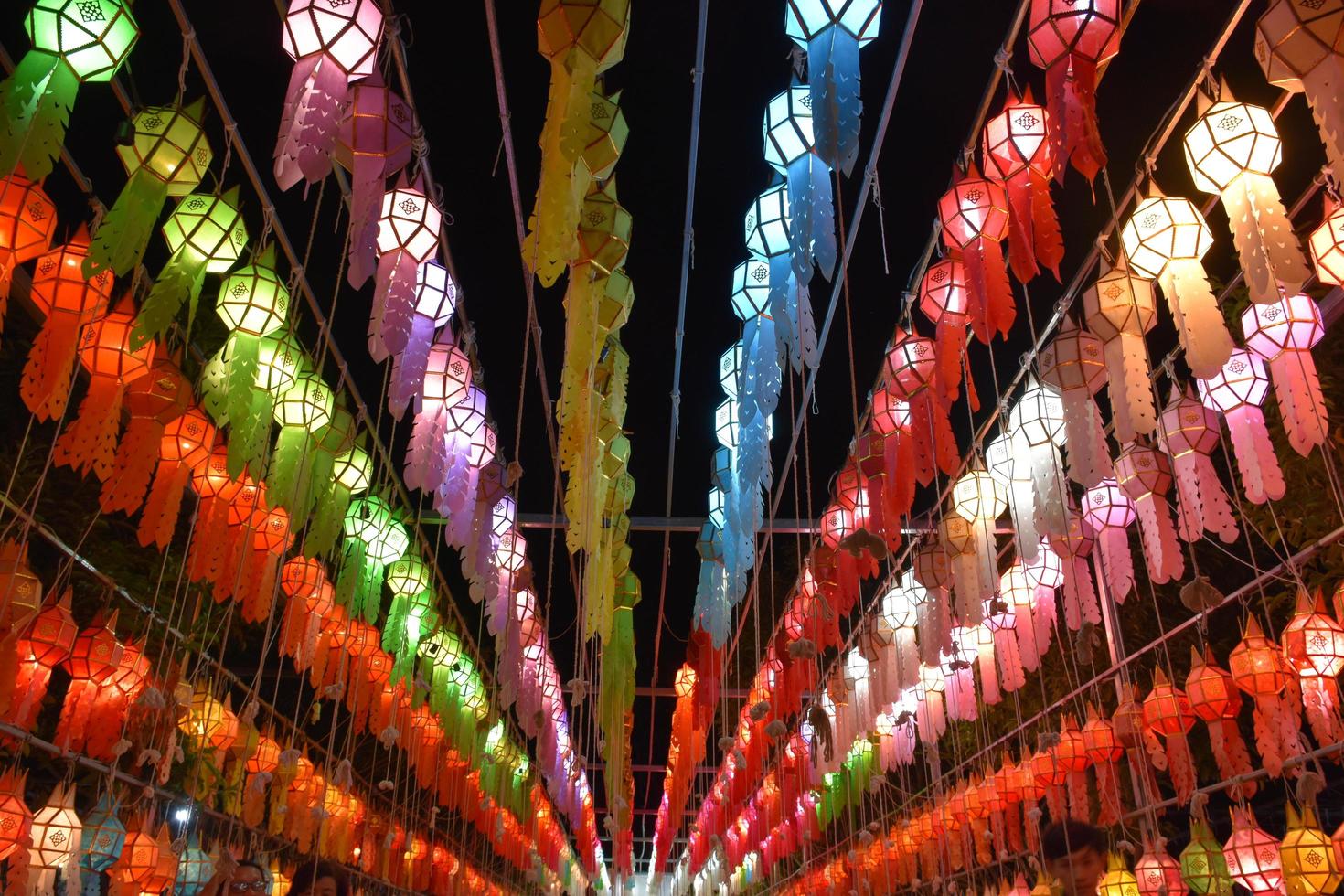 Beautifully shaped and colorful paper lanterns are hung in front of a pagoda to worship Lord Buddha in a temple in northern Thailand. photo