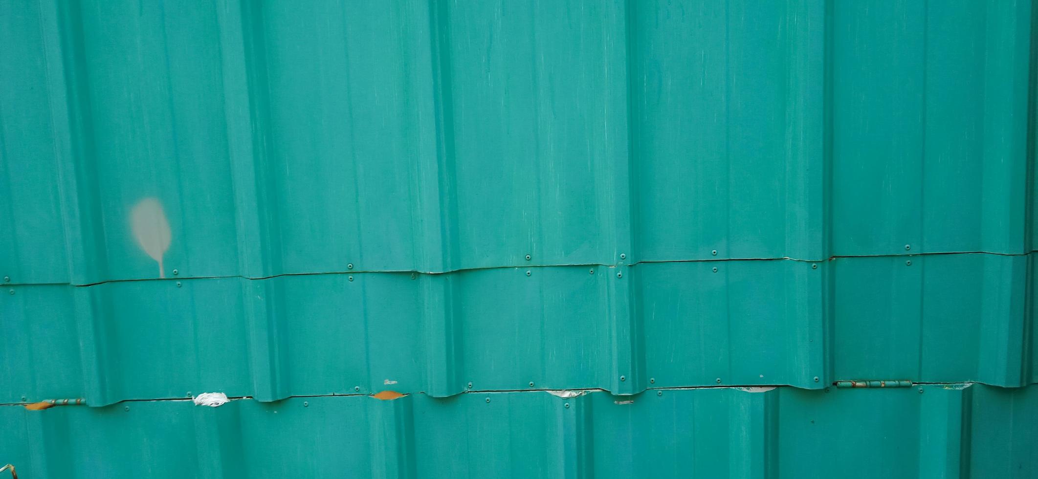 Greenery metallic fence made of corrugated steel sheet with vertical textures. photo