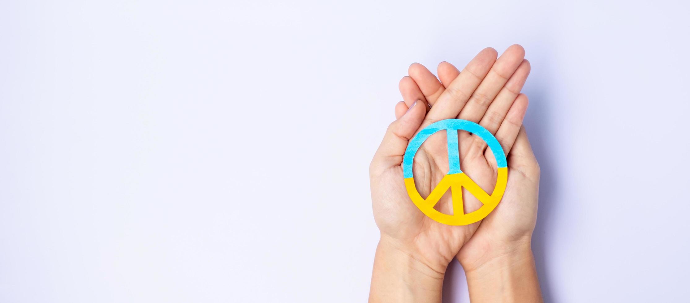 Support for Ukraine in the war with Russia, Hands holding symbol of peace with flag of Ukraine. Pray, No war, stop war, stand with Ukraine and Nuclear Disarmament photo