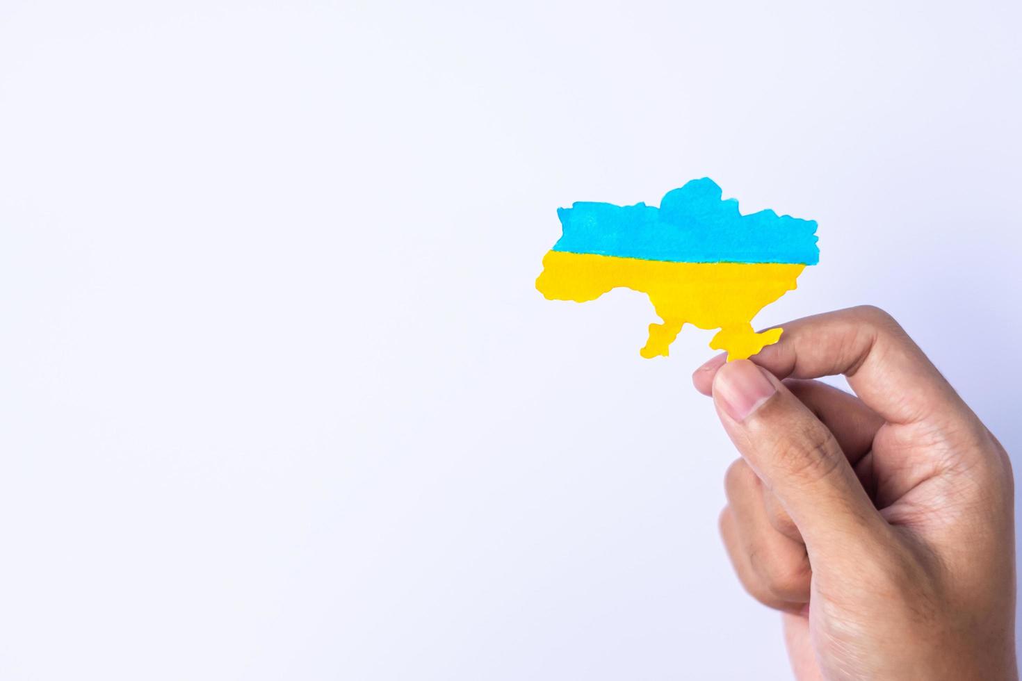 Support for Ukraine in the war with Russia, Hands holding the shape of Ukraine border with color flag. Pray, No war, stop war and stand with Ukraine photo