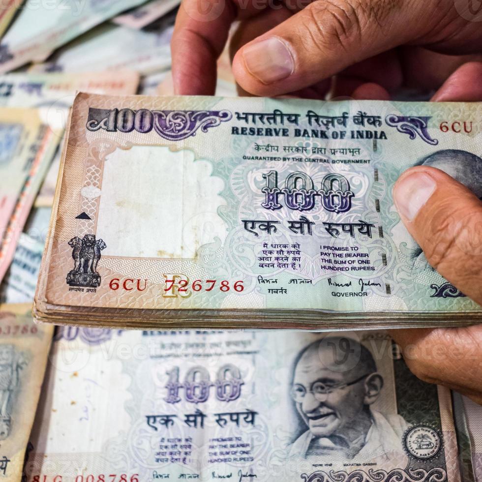 Old One Hundred Rupee notes combined on the table, India money on the rotating table. Old Indian Currency notes on a rotating table, Indian Currency on the table photo